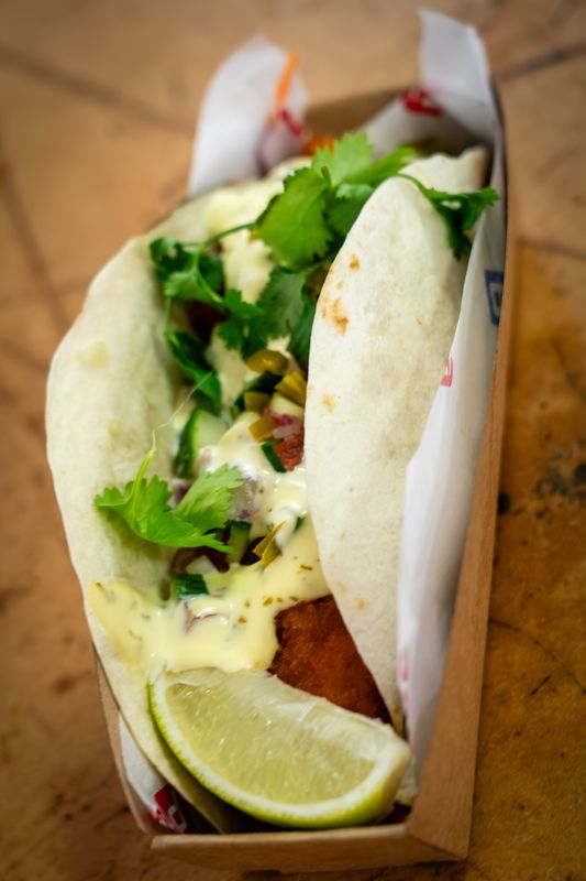 A soft taco with lime and coriander from a festival food station
